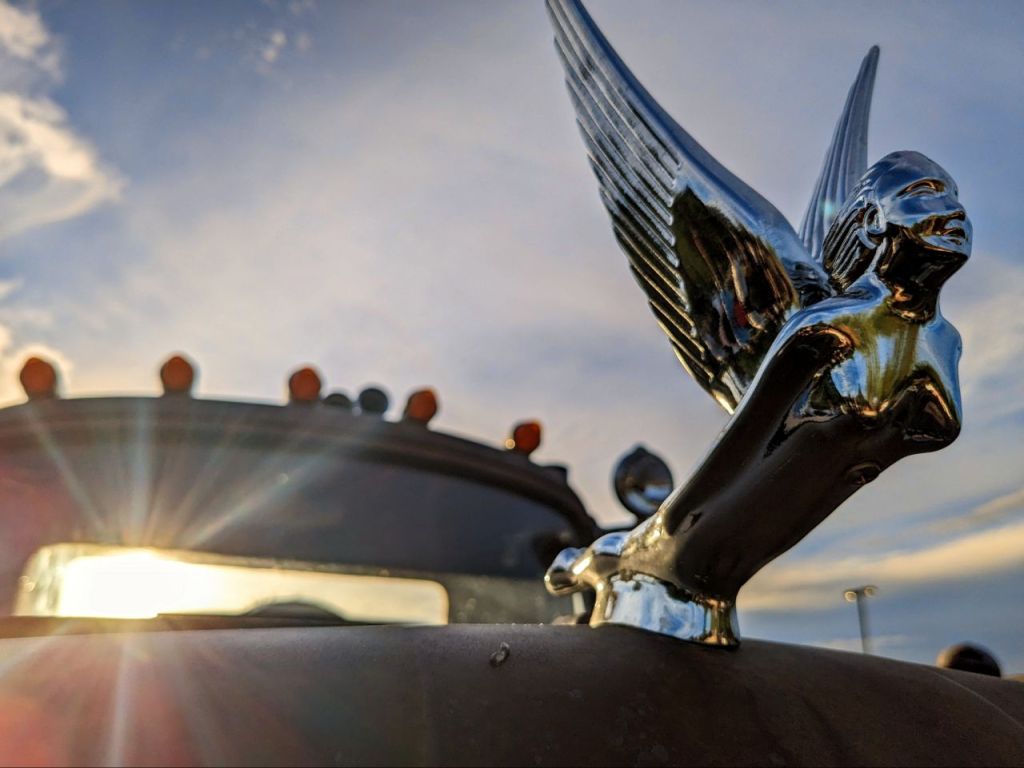 Close-up of an angel ornament on the hood of a rustic truck