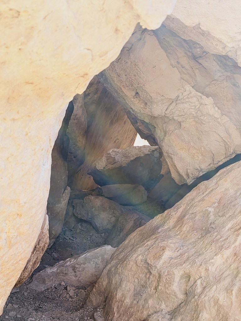 A rainbow illusion forms in front of a rock formation