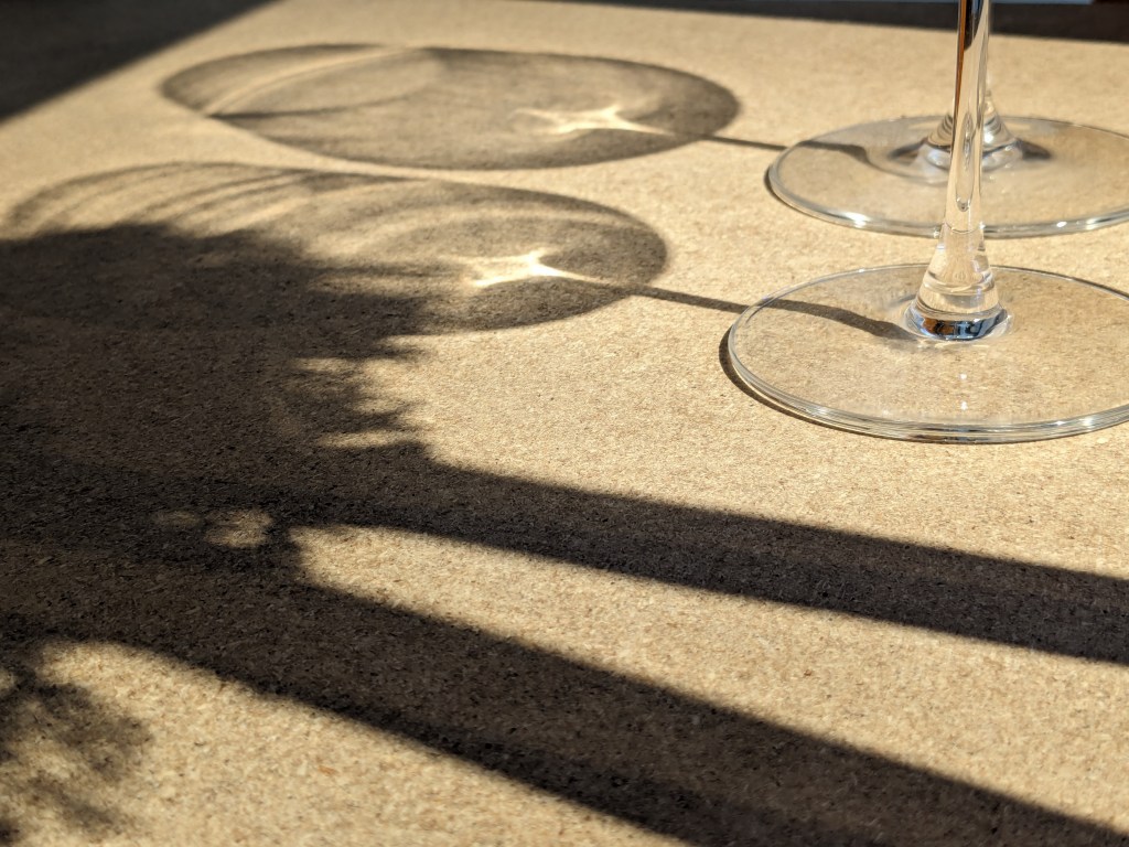 Shadows of two wine glasses and a Christmas wreath
