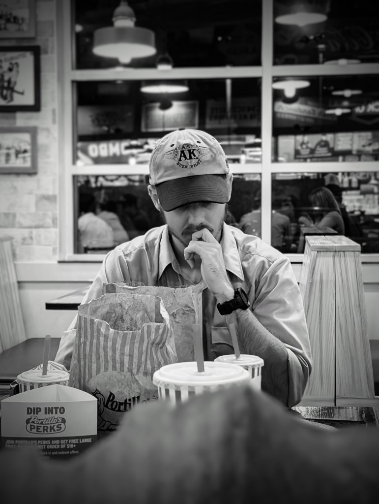 A man wrapped up in his thoughts at a restaurant table